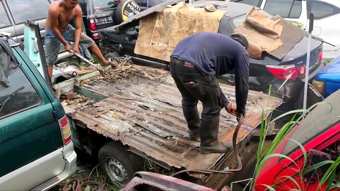 Pemotongan bodi mobil di lapak kampakan