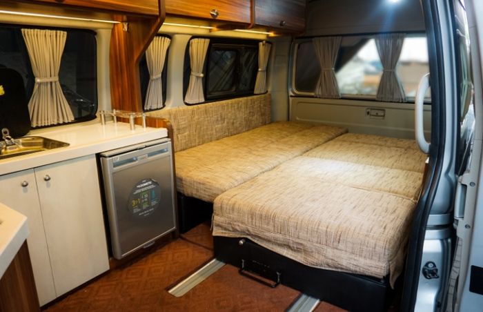 Ilustrasi interior Motorhome dengan sofa bed dan kitchen set. 