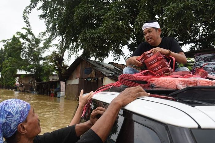 Anggota DPR RI, Dedi Mulyadi membagikan nasi box ke warga di tengah kepungan banjir