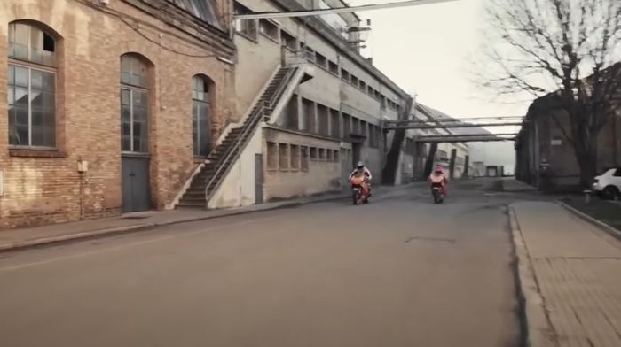 Marc Marquez dan Pol Espargaro terlihat melaju di sebuah jalan dekat pabrik/gudang