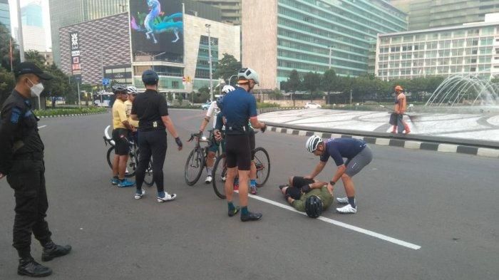 Petugas keamanan menolong pesepeda yang menjadi korban tabrak lari, di Bundaran Hotel Indonesia, Jalan MH Thamrin, Jakarta Pusat, Jumat (12/3/2021) pagi. 