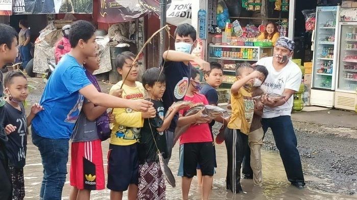 Masyarakat Desa Tamansari, Ciapus, Kabupaten Bogor, Jawa Barat, melakukan aksi memancing lele di jalan rusak, wujud protes atas rusaknya ruas jalan di daerah tersebut. (Tribunnews/istimewa)