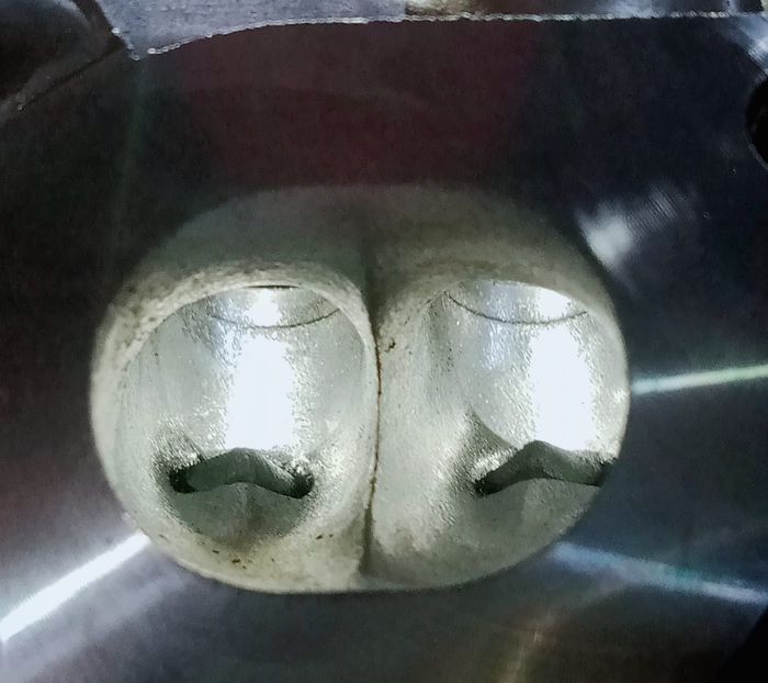 Lubang port sedikit di-porting dan polished agar aliran campuran udara dan bahan bakar lebih maksimal