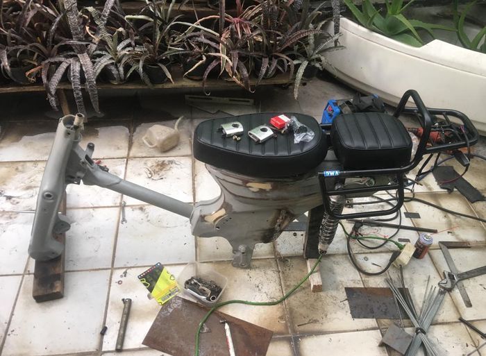 Rangka Honda C70 dengan jok custom saat proses perakitan motor listrik