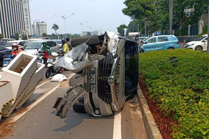 Toyota Avanza terguling dan hancur usai tendang beton pembatas sepeda di Jl Jenderal Sudirman, Jakarta Pusat