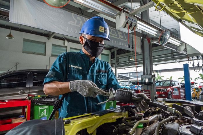 Mekanik sedang mengerjakan perbaikan maupun perawatan salah satu mobil konsumen di bengkel resmi Suzuki.