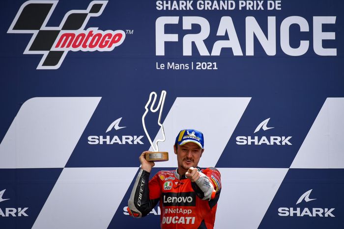 Pembalap Ducati, Jack Miller, berpose dengan trofi juara MotoGP Prancis di Sirkuit Le Mans, Minggu (16/5/2021).