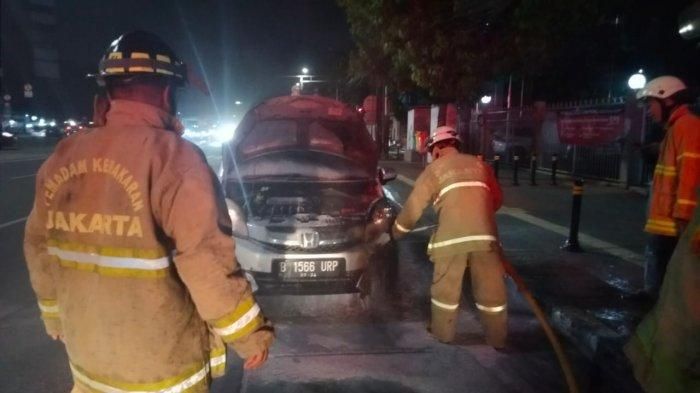 Proses pemadaman api yang membakar Honda Mobilio di Jl Matraman Raya, Jakarta Timur