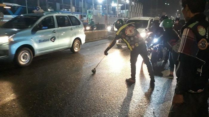 Komunitas Ojol Tebar (Team Berantas Ranjau) tengah mencari ranjau paku yang bertebaran di Jalan Gatot Subroto pada Jumat (21/5/2021).