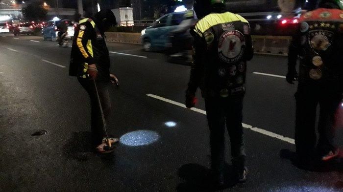 Komunitas Ojol Tebar (Team Berantas Ranjau) tengah mencari ranjau paku yang bertebaran di Jalan Gatot Subroto pada Jumat (21/5/2021). (TRIBUNJAKARTA.COM/SATRIO SARWO TRENGGINAS)