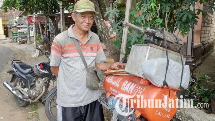 Tri Budoyo saat menambal ban pelanggannya via online, di Desa Bejagung, Kecamatan Semanding, Tuban, Selasa (1/6/2021). 