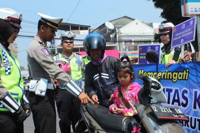 KBO Satlantas Polres Garut Iptu Tejo Reno saat menghentikan sepeda motor yang membawa anak kecil tanpa helm di jalan Ahmad Yani Garut Kota(Kompas.com/Ari Maulana Karang)