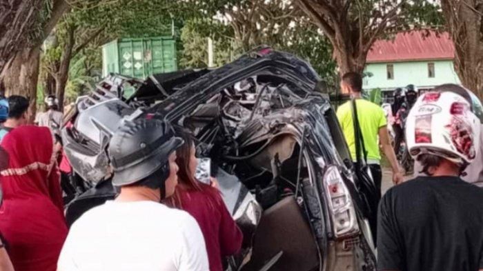 Warga mengevakuasi mobil yang ringsek