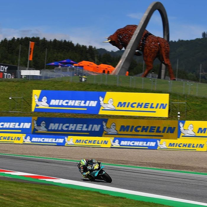 Valentino Rossi yang melibas tikungan dengan background Bull of Spielberg di Sirkuit Red Bull Ring