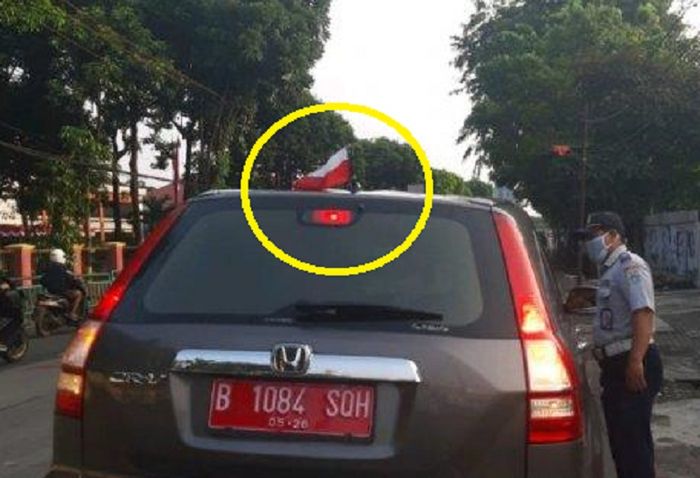 Anggota Dishub Jaksel menghentikan Sebuah Mobil Honda CR-V berpelat nomor merah di Jalan Ciputat Raya, Kebayoran Lama, Jakarta Selatan pada Rabu (25/8/2021). Mobil itu dihentikan karena memasang bendera merah putih terbalik. 