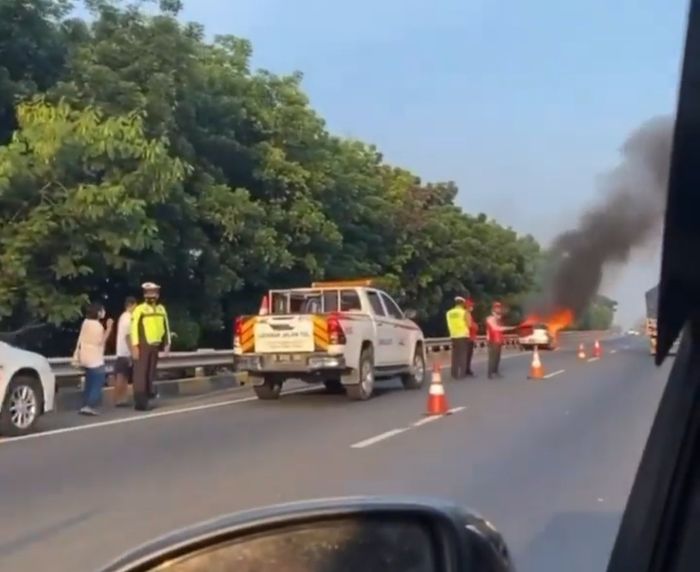 Petugas mengamankan lokasi kejadian Peugeot 306 yang terbakar di Tol JORR