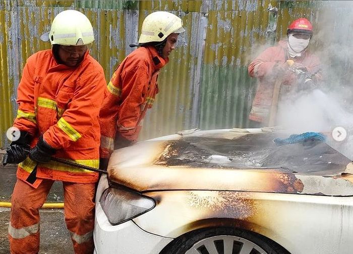 Petugas Pemadam Kebakaran berusaha mencongkel untuk menyemprot ruang mesin yang terbakar