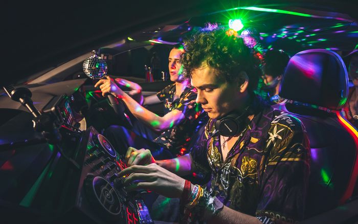 DJ Woody Cook memainkan mixing deck di kursi penumpang Ibiza Nightclub.