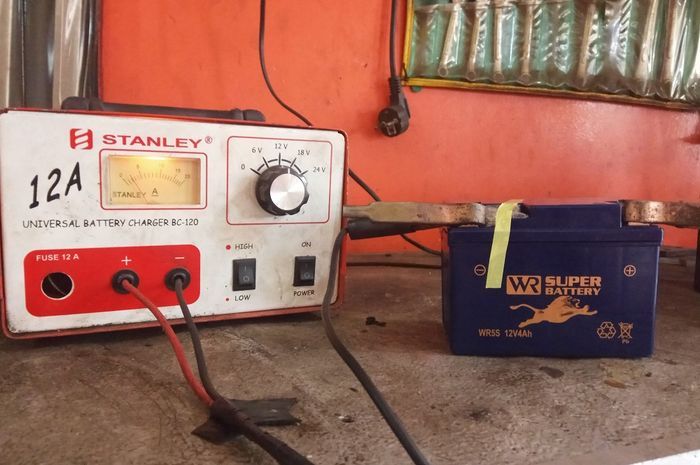 Lakukan charge pada aki motor yang tekor agar kerjanya kembali normal