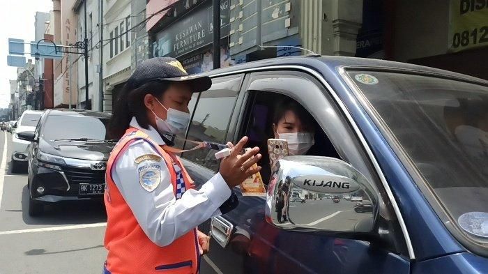 Petugas parkir di kota Medan menunjukan kode scan QRIS