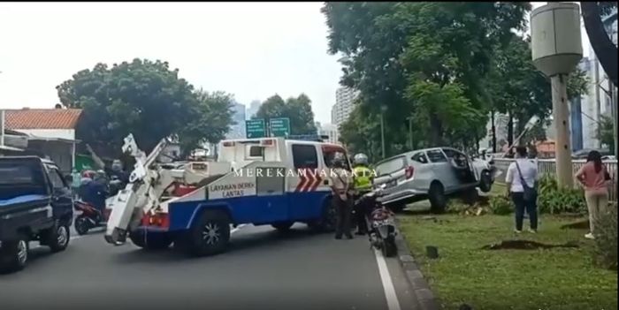 Petugas kepolisian mengevakuasi Daihatsu Sigra tabrak tiang lampu penerangan jalan di Jl KH. Abdullah Syafei, Manggarai Selatan, Tebet, Jakarta Selatan