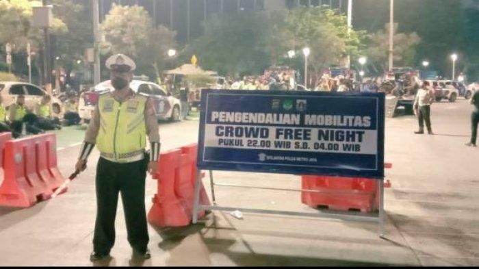 Seorang polisi lalu lintas berjaga di depan lokasi penutupan areal crowd free night ( CFN) di salah satu kawasan di DKI Jakarta