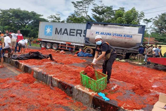 Relawan membersihkan cabai yang tumpah karena kecelakaan di Jalan Lingkar Salatiga 