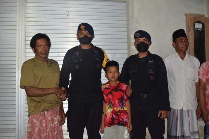 Faris (tengah) bocah 9 tahun yang menghilang dari rumahnya selama 17 bulan dan ditemukan di area Sirkuit Mandalika oleh anggota Brimob