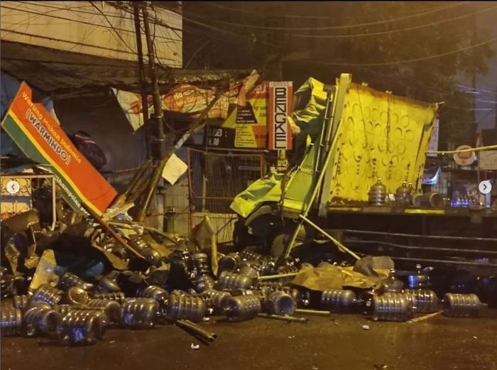 Puluhan galon air berserakan setelah truk pengakut tabrak bangunan, angkot dan pejalan kaki di Jl Cihampelas, kota Bandung, Jawa Barat