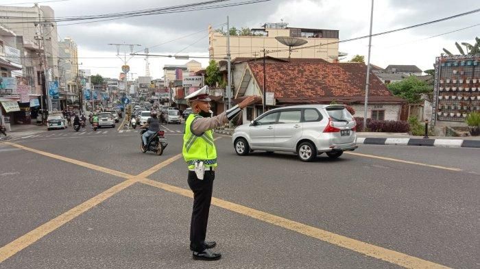 Petugas kepolisian dari Satlantas Polres Pangkalpinang saat mengatur arus lalu lintas di Simpang Semabung. Hal itu setelah lampu pengatur lalu lintas atau traffic light mengalami kerusakan akibat tersambar petir, Sabtu (5/2/2020) pagi  