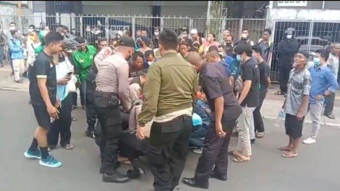 Warga dan anggota Polres Metro Jakarta Timur saat mengevakuasi oknum Polisi depresi dan ngamuk di Matraman, Jaktim