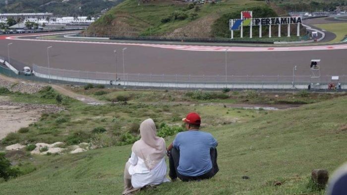 Gubernur NTB Zulkieflimasyah bersama istri, Niken Widiawati saat menonton sesi kualifikasi MotoGP Mandalika 2022 dari atas Bukit Seger dengan lanskap Sirkuit Mandalika pada Sabtu, (19/3/2022). 