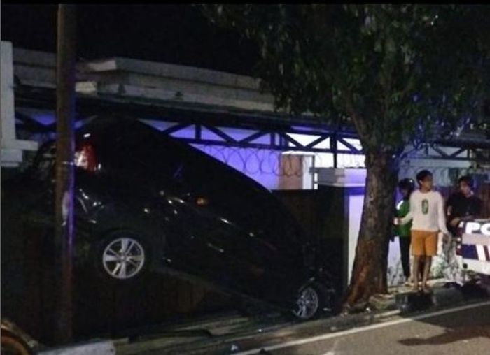 Toyota Veloz kecelakaan kejepit antara pohon dan tiang listrik di depan rumah warga di Jalan Raya Kramat Pela, Kebayoran Baru, Jakarta Selatan