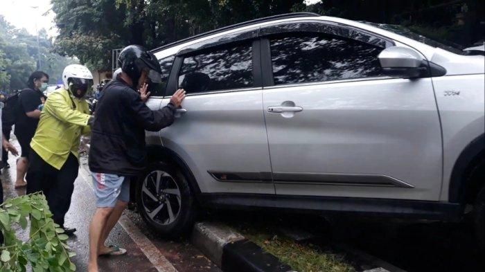 Evakuasi Toyota Rush dari pembatas jalan usai tabrak tiang lampu penerangan jalan di Duren Sawit, Jakarta Timur