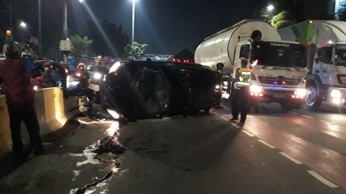 Toyota Sienta hitam nopol B 1024 UIT terguling di Jl Mayjen Sutoyo, Kramat Jati, Jakarta Timur