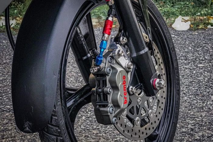 Kaki depannya mendapatkan garpu Supra GTR 150, pelek palang tiga, dan pengereman berkaliper Brembo