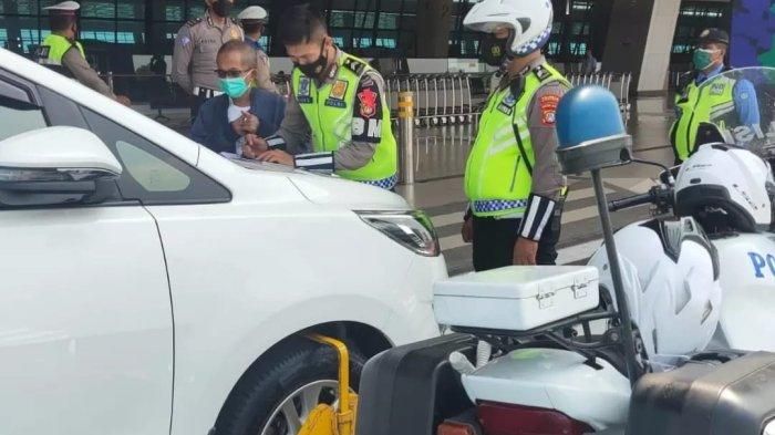Polisi menggembok dan beri sanksi tilang pada Toyota Kijang Innova yang parkir di drop zone terminal 3 Bandara Soekarno-Hatta