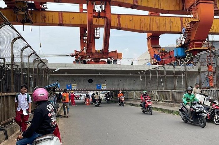 Awas, pemotor harus nunduk saat melewati girder Kereta Cepat Jakarta-Bandung yang terlalu rendah di Pondok Gede, Bekasi, Jawa Barat.