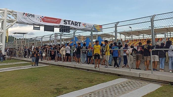 Penonton di area pit lane saat menyaksikan drag bike di sirkuit Mandalika Minggu, (19/6/2022) 