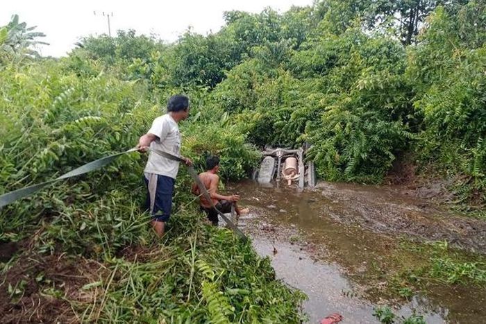Posisi Kijang Innova berisi satu keluarga Kakanwil Kemenag Kalteng saat masih tertancap di parit berlumpur