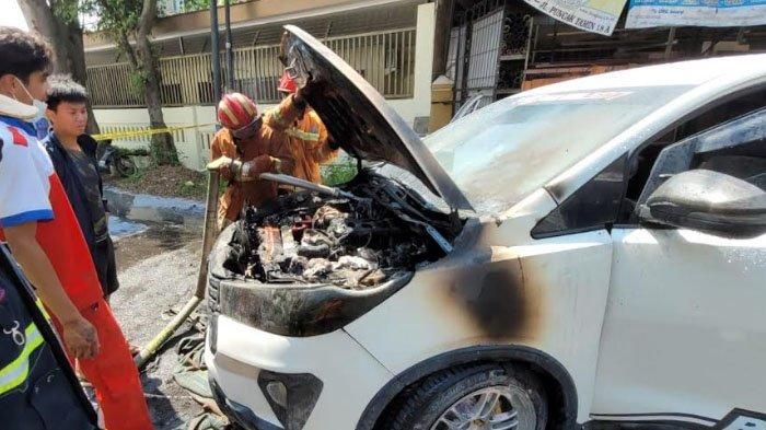 Petugas UPT PMK Kota Malang saat melakukan pemadaman Toyota Innova Venturer yang terbakar, Selasa (19/07)