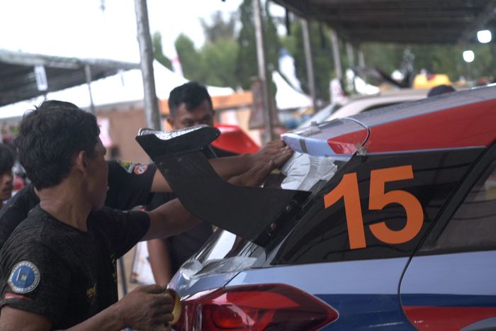 Mekanik tim HVRT memasang kembali kaca belakang Hyundai i20 R5 mereka.