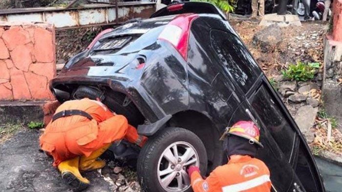 Proses evakuasi Toyota Avanza terjungkal ke dalam parit di jalan raya Jemursari, Wonocolo, kota Surabaya, Jawa Timur