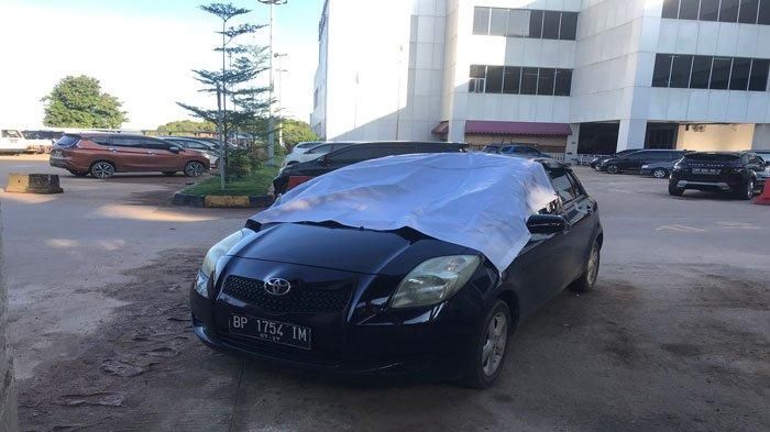 Kondisi mobil Toyota Yaris, tempat tubuh Syaiful mendarat setelah lompat dari Flyover Pelabuhan Punggur Batam, tampak ditutup terpal, Selasa (11/10/2022).