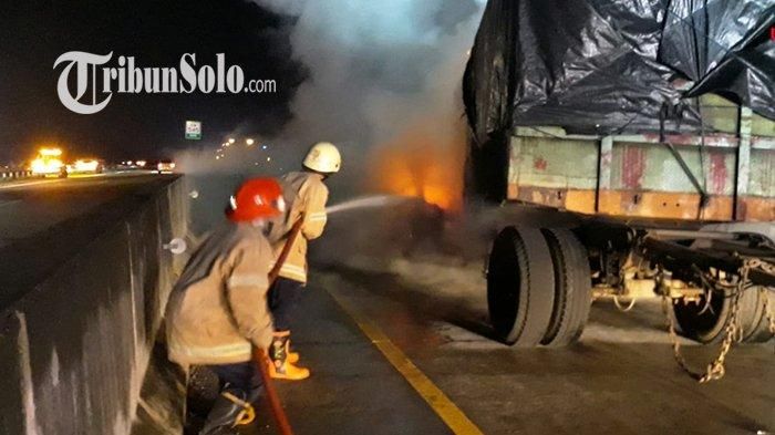 Pemadam kebakaran memadamkan api yang membakar Nissan X-Trail dan truk gandeng di ruas tol Solo-Ngawi