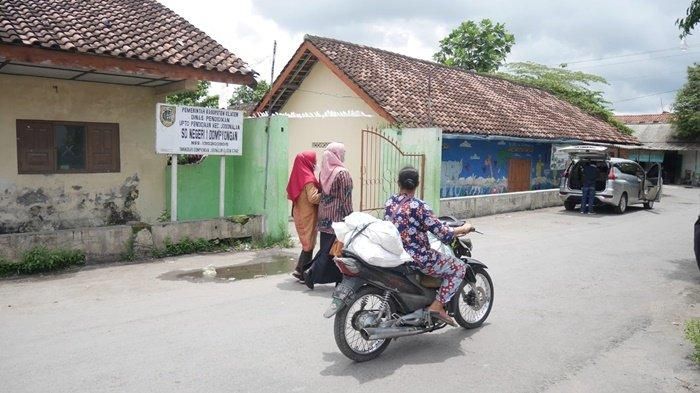 Warga melintas di depan SDN 1 Dompyongan, Jogonalan, Klaten, yang bakal kena terjang proyek Tol Yogyakarta-Solo Kamis (27/10/2022).