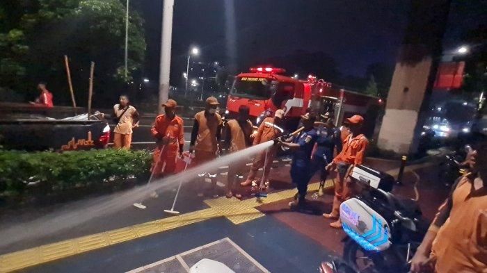 Puluhan petugas PPSU dibantu petugas pemadam kebakaran melakukan pembersihan di sekitar Halte Stasiun Palmerah dan sekitarnya, Kelurahan Gelora, Tanah Abang, Jakarta Pusat pada Selasa (8/11/2022) malam, menyusul keluhan pejalan kaki adanya bau pesing menyengat di lokasi.