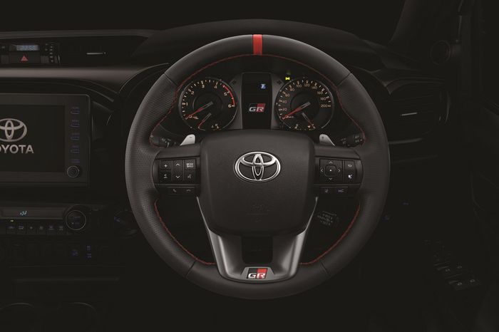 Setir Toyota New Hilux GR Sport dibalut bahan kulit halus dan bergurat, lengkap dengan aksen GR Red Leather Center Mark Addition serta pola jahitan Kagari berpola huruf Z yang unik bersanding bersama new bezel, GR Emblem, dan paddle shift