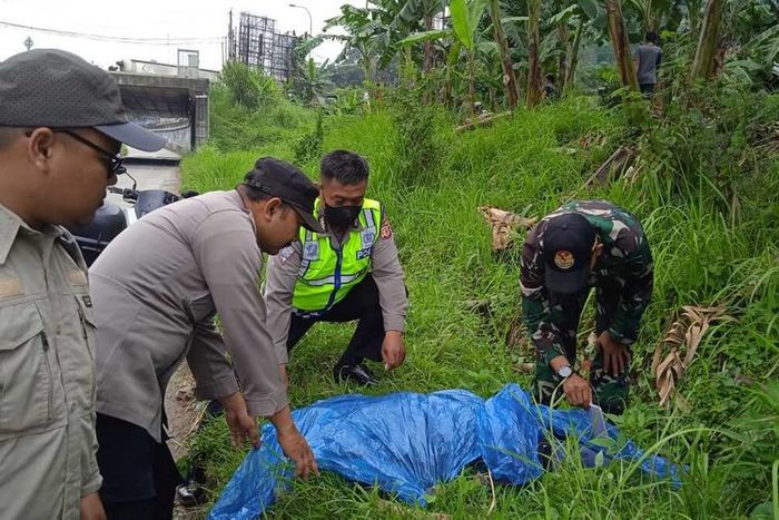 Petugas mengevakuasi jasad bocah yang tewas terlindas truk akibat bikin konten adang truk di pintu tol Gunung Putri, Bogor