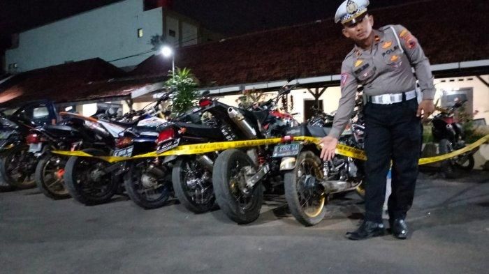 KBO Satlantas Polresta Pati Ipda Muslimin menunjukkan sepeda motor berknalpot brong yang terjaring razia, Senin (6/2/2023).  